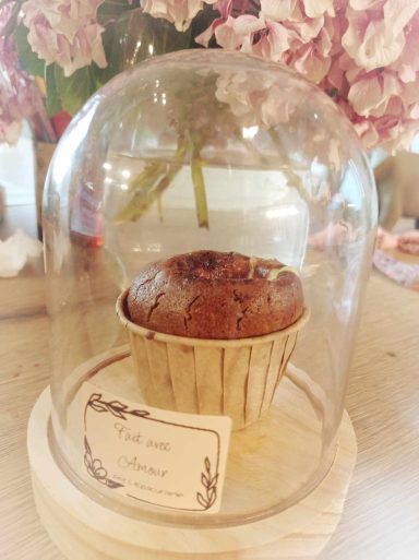 une cloche à dessert avec un gateau au chocolat