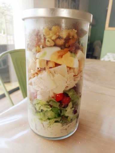 un pot rempli des ingrédients d'une salade césar